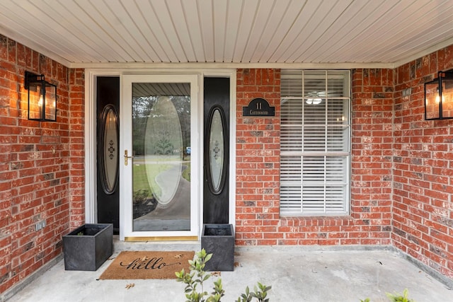 doorway to property with brick siding