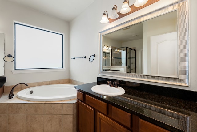 bathroom featuring a garden tub, vanity, visible vents, and a stall shower