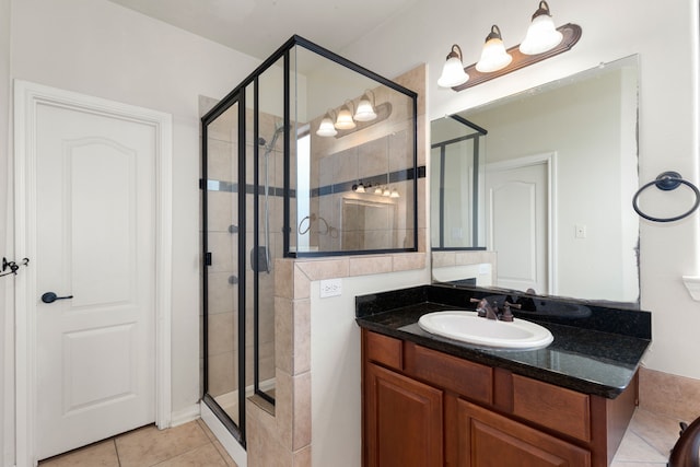 full bath with tile patterned flooring, a shower stall, and vanity