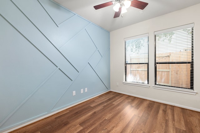 spare room with ceiling fan, wood finished floors, and baseboards