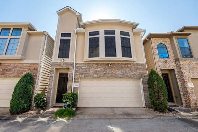 view of property featuring a garage, stone siding, driveway, and stucco siding