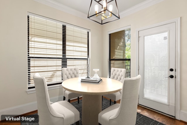 dining space with a chandelier, crown molding, baseboards, and wood finished floors