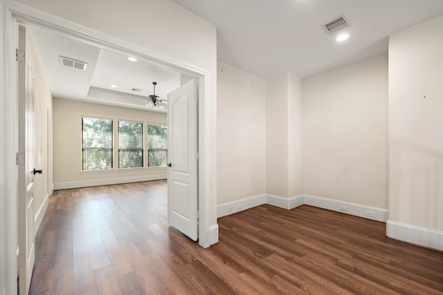 spare room with recessed lighting, visible vents, a tray ceiling, and wood finished floors