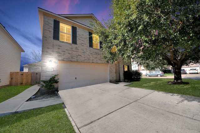 traditional-style house with driveway, an attached garage, fence, and brick siding