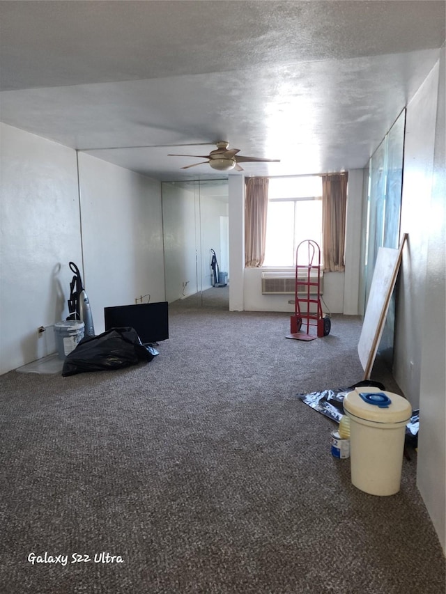 interior space with a textured ceiling, carpet floors, and a ceiling fan