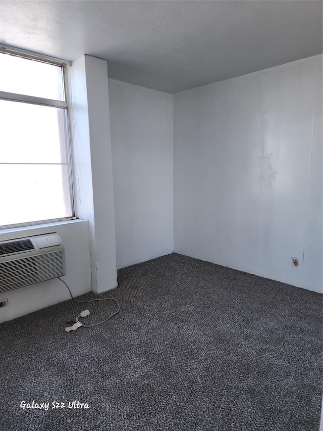 carpeted spare room with a wall mounted air conditioner