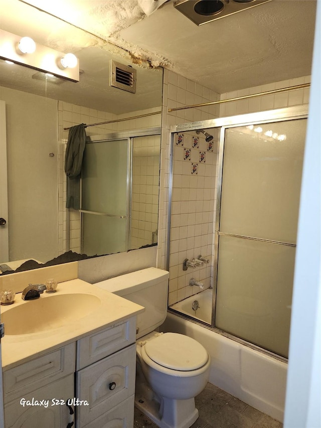 full bath with visible vents, toilet, tile patterned floors, combined bath / shower with glass door, and vanity