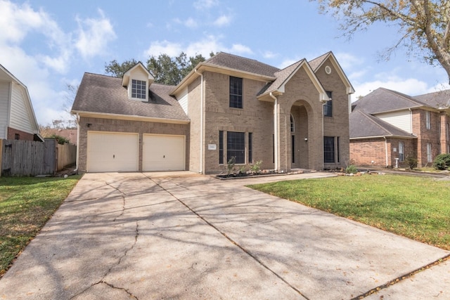 traditional-style house with an attached garage, brick siding, fence, driveway, and a front lawn