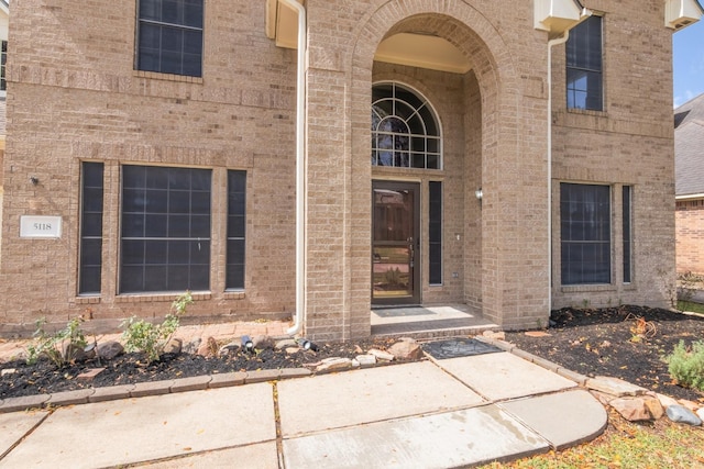 entrance to property featuring brick siding