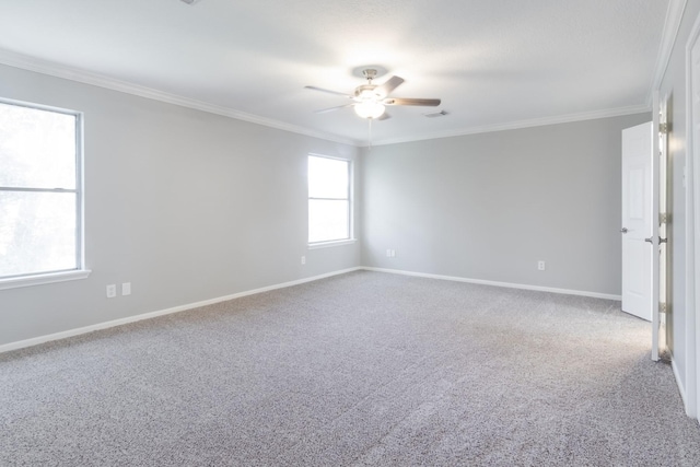 carpeted empty room featuring ornamental molding, visible vents, ceiling fan, and baseboards