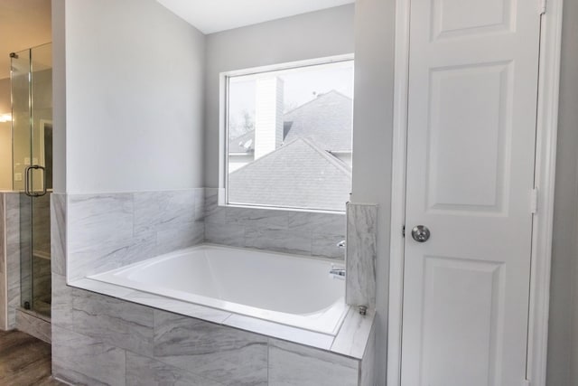 bathroom featuring a stall shower and a garden tub