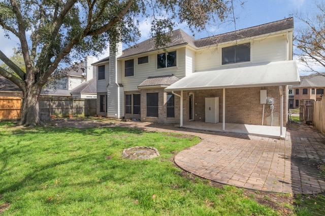 back of property with a yard, a fenced backyard, a patio, and brick siding