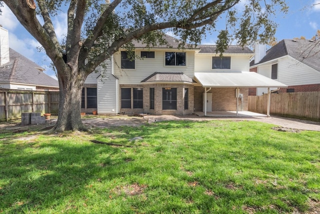 view of front facade featuring a patio, brick siding, a front lawn, and a fenced backyard