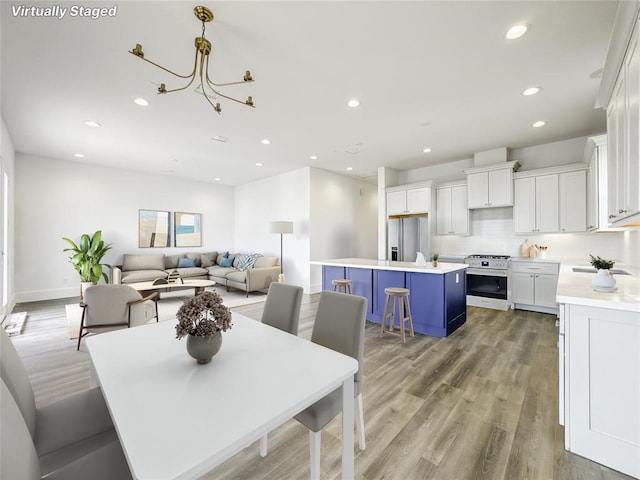 dining space featuring light wood-type flooring, baseboards, and recessed lighting