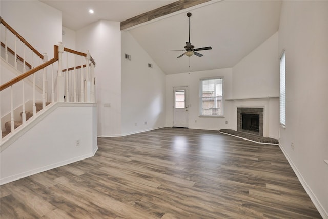 unfurnished living room with ceiling fan, stairs, beamed ceiling, and wood finished floors