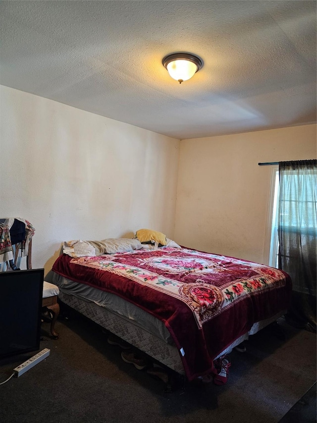 bedroom with carpet and a textured ceiling