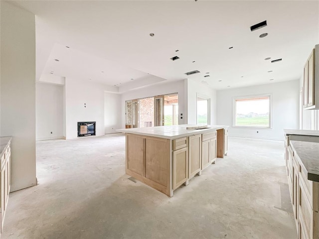 kitchen with open floor plan, a glass covered fireplace, and a center island