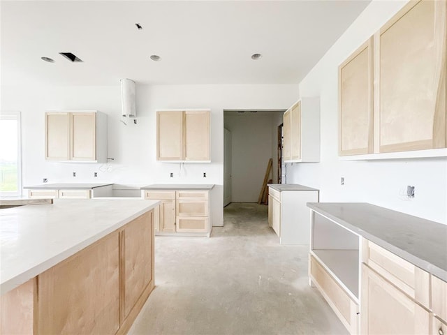 kitchen featuring light brown cabinets and unfinished concrete flooring