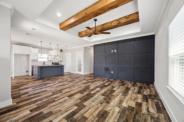 unfurnished living room featuring ornamental molding, dark wood finished floors, and baseboards