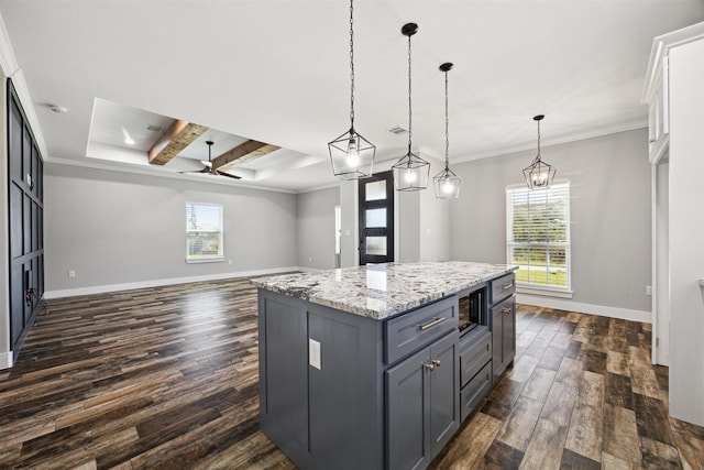 kitchen with baseboards, dark wood finished floors, a center island, crown molding, and gray cabinetry