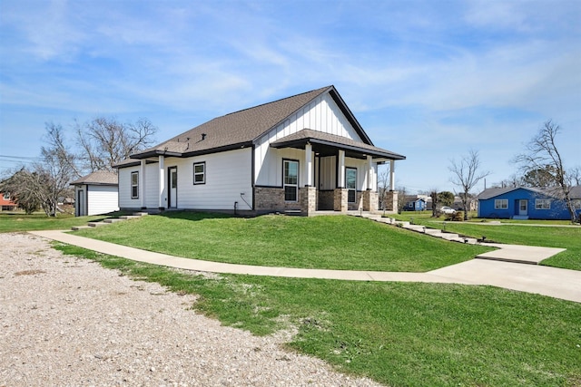 view of front of property featuring driveway, roof with shingles, covered porch, board and batten siding, and a front yard