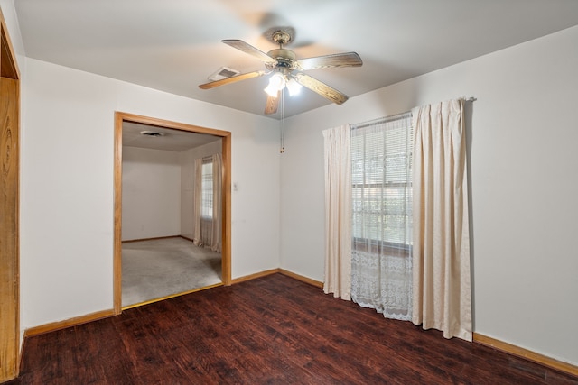 spare room with ceiling fan, wood finished floors, visible vents, and baseboards