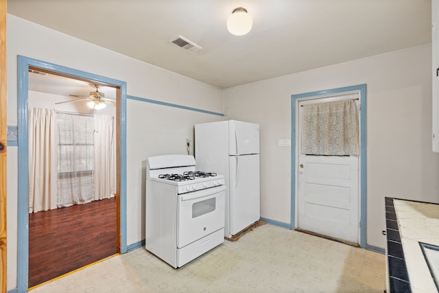 kitchen featuring ceiling fan, white appliances, visible vents, baseboards, and light floors