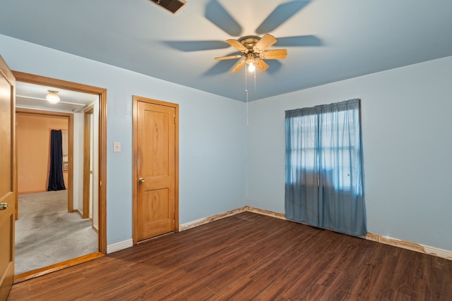 unfurnished room featuring ceiling fan, wood finished floors, visible vents, and baseboards