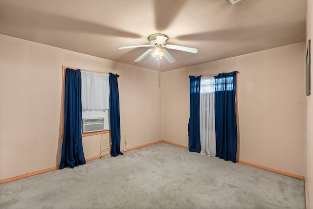 empty room featuring carpet floors, cooling unit, a ceiling fan, and baseboards