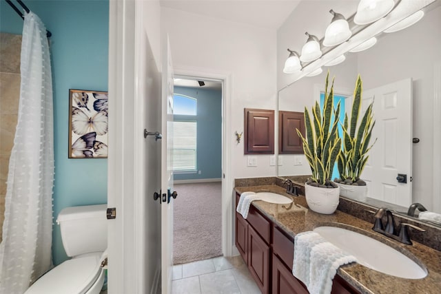 full bath with tile patterned flooring, a sink, toilet, and double vanity