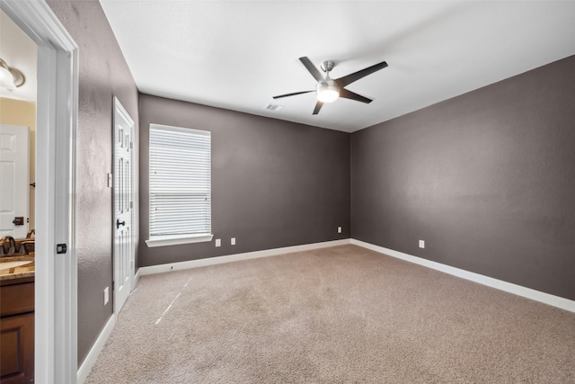 unfurnished room featuring light carpet, ceiling fan, and baseboards