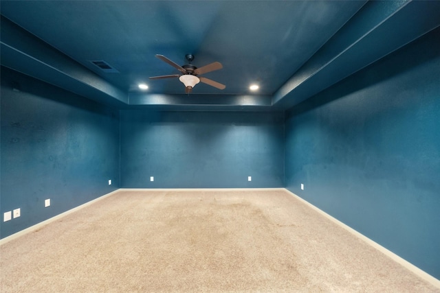 unfurnished room with baseboards, visible vents, a ceiling fan, a tray ceiling, and carpet floors