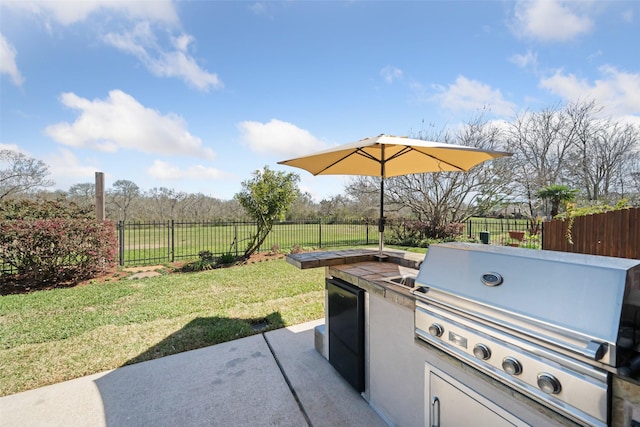 view of patio with area for grilling, grilling area, and a fenced backyard