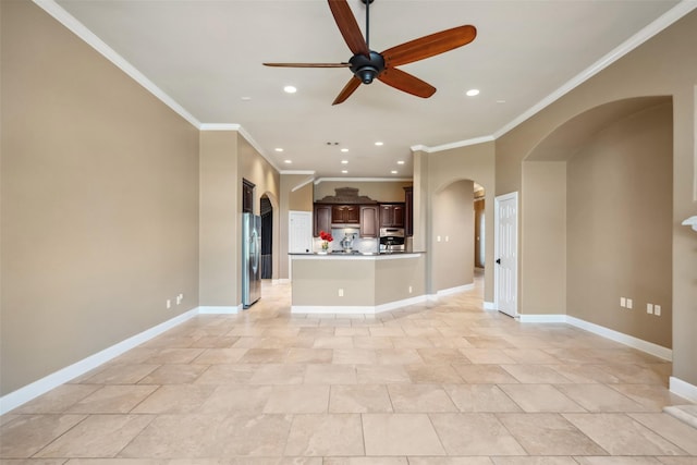 unfurnished living room with arched walkways, recessed lighting, ornamental molding, a ceiling fan, and baseboards