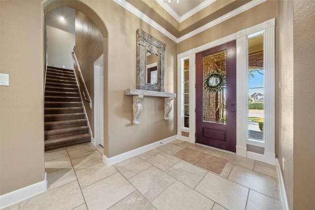 foyer with stairs, baseboards, crown molding, and tile patterned floors