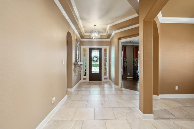 entrance foyer featuring a notable chandelier, baseboards, arched walkways, and crown molding