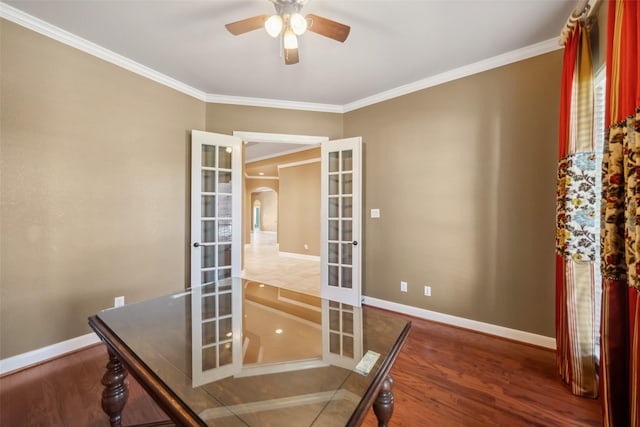 office space featuring baseboards, arched walkways, wood finished floors, and french doors