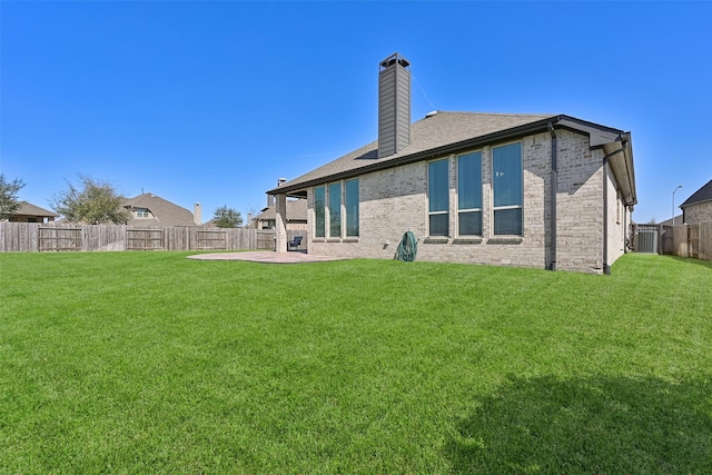 rear view of property with a patio area, a fenced backyard, a lawn, and brick siding