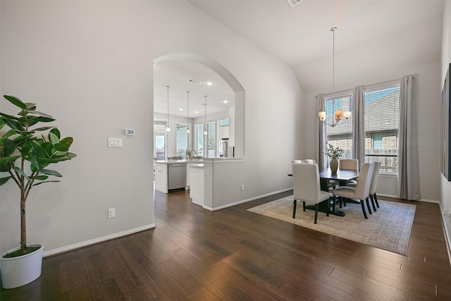 dining area featuring baseboards, visible vents, arched walkways, lofted ceiling, and dark wood-style flooring