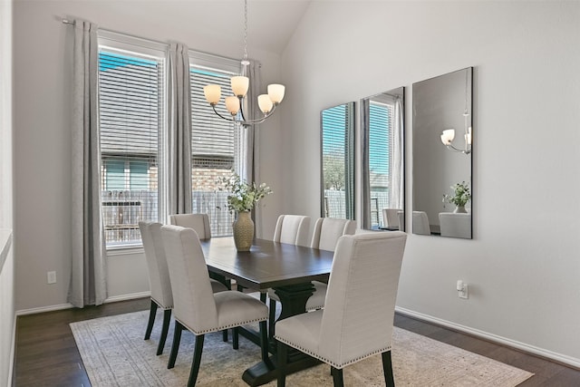 dining space featuring an inviting chandelier, vaulted ceiling, a wealth of natural light, and wood finished floors