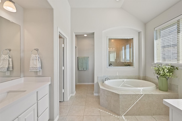 full bath featuring lofted ceiling, vanity, a bath, and tile patterned floors