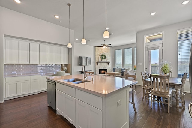 kitchen with tasteful backsplash, dark wood-style flooring, a fireplace, and a sink