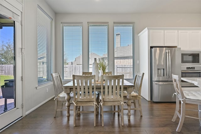 dining area featuring dark wood-type flooring and baseboards