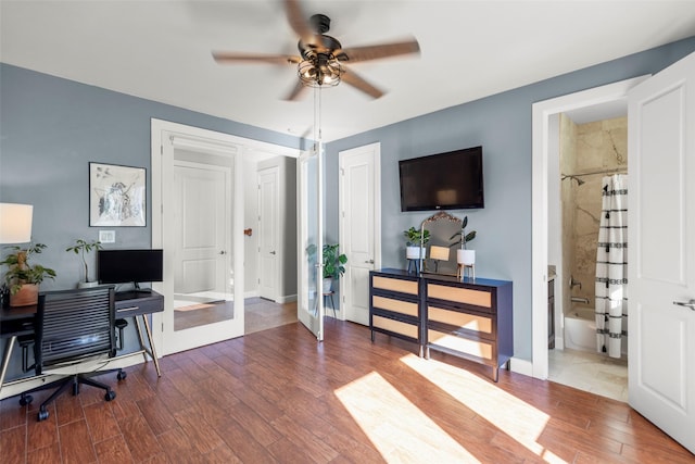 office space featuring a ceiling fan, baseboards, and wood finished floors