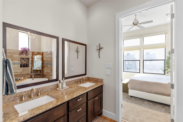 bathroom featuring ceiling fan, a sink, baseboards, and double vanity