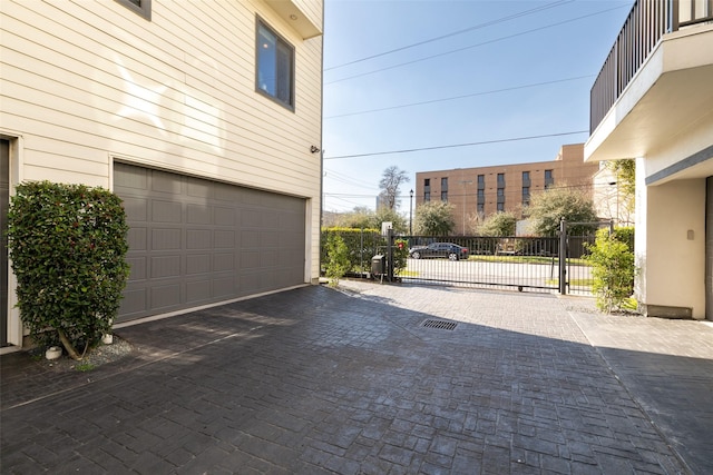 garage with driveway and a gate