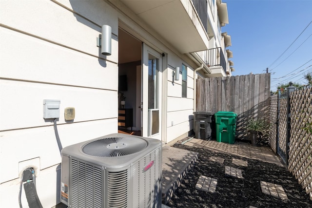 exterior details with central air condition unit and fence