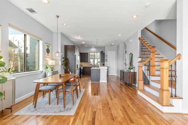 dining space with light wood-style flooring, stairs, visible vents, and recessed lighting