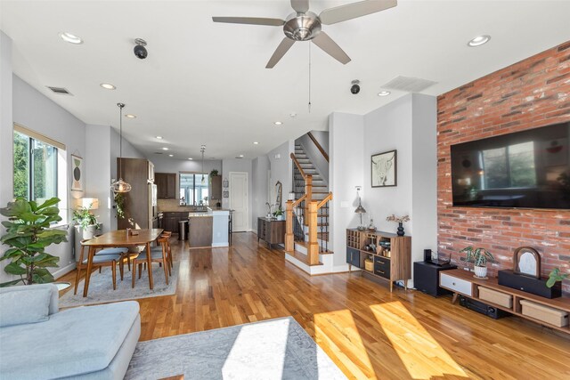 living room with recessed lighting, visible vents, light wood-style floors, baseboards, and stairs