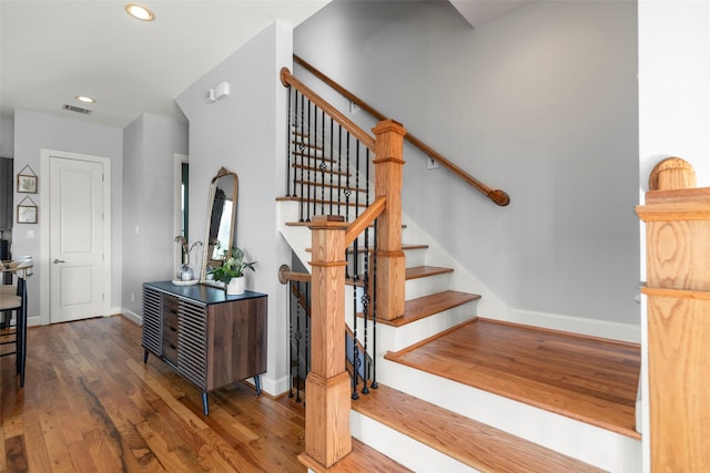 stairs with baseboards, visible vents, wood finished floors, and recessed lighting